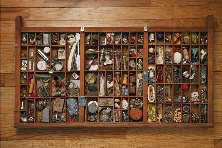 A drawer filled with small found objects and materials for assemblage work