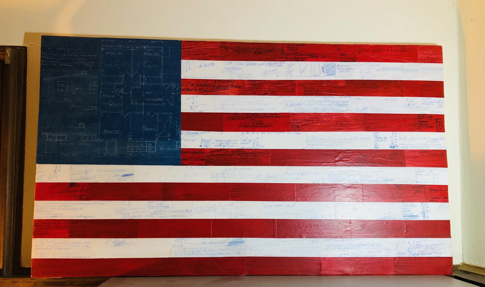 Large flag assemblage with blueprint-like blue field and handwritten markings across red and white stripes