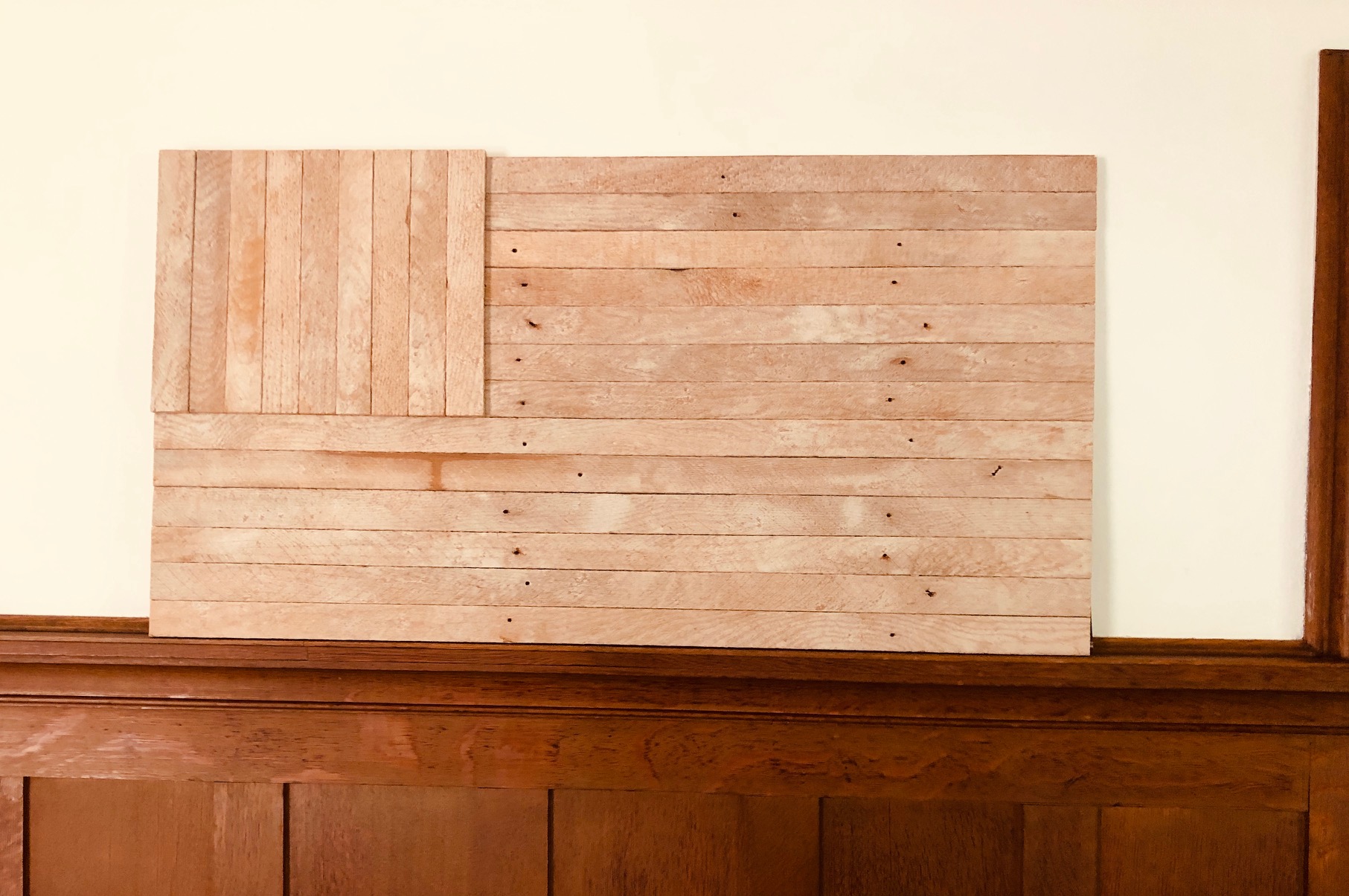 Unpainted wood flag form leaning against a wall